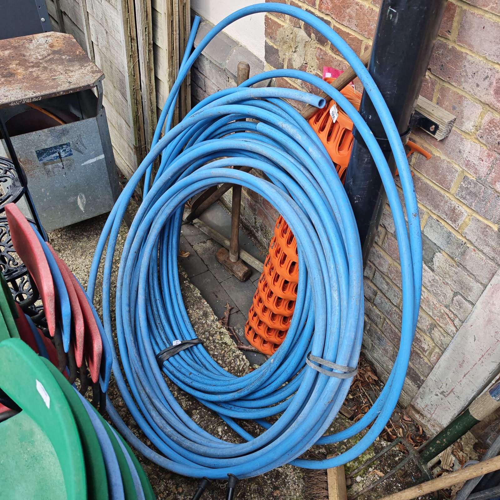 Two lengths of blue plastic piping coiled for storage.