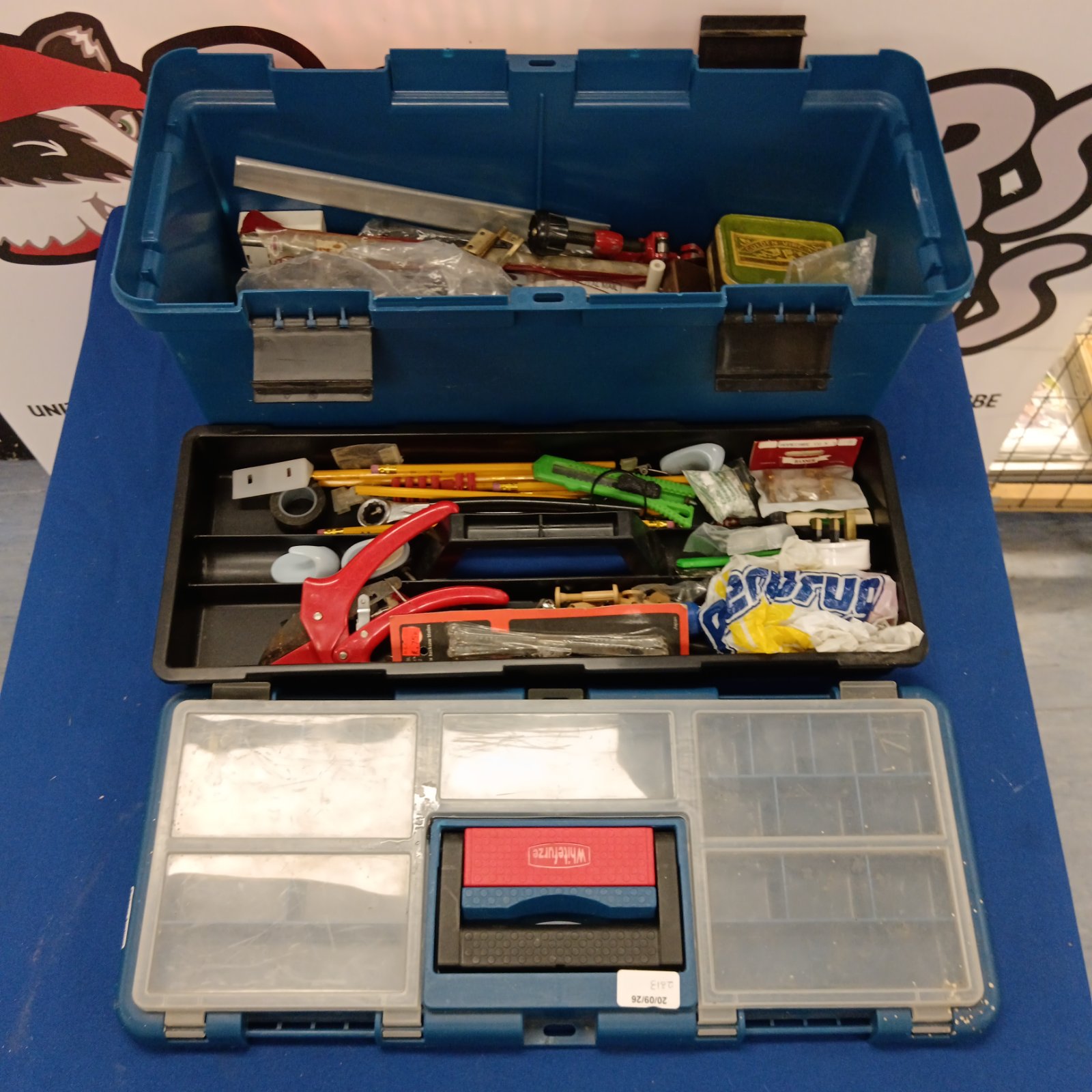 Blue plastic toolbox filled with assorted hand tools and small parts.