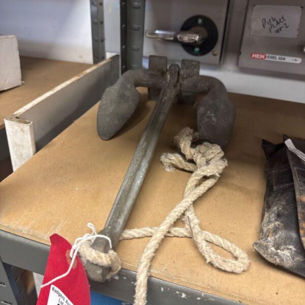 Vintage boat drag anchor with rope attached, showing corrosion.