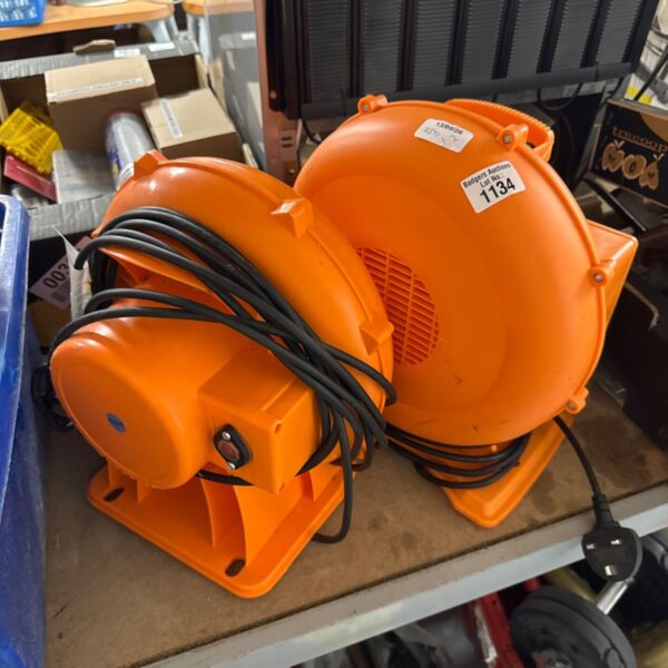 Orange bouncy castle blower motor with fan and handle.