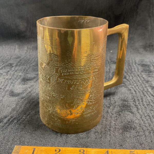 Vintage brass North Africa campaign tankard with detailed engraving.