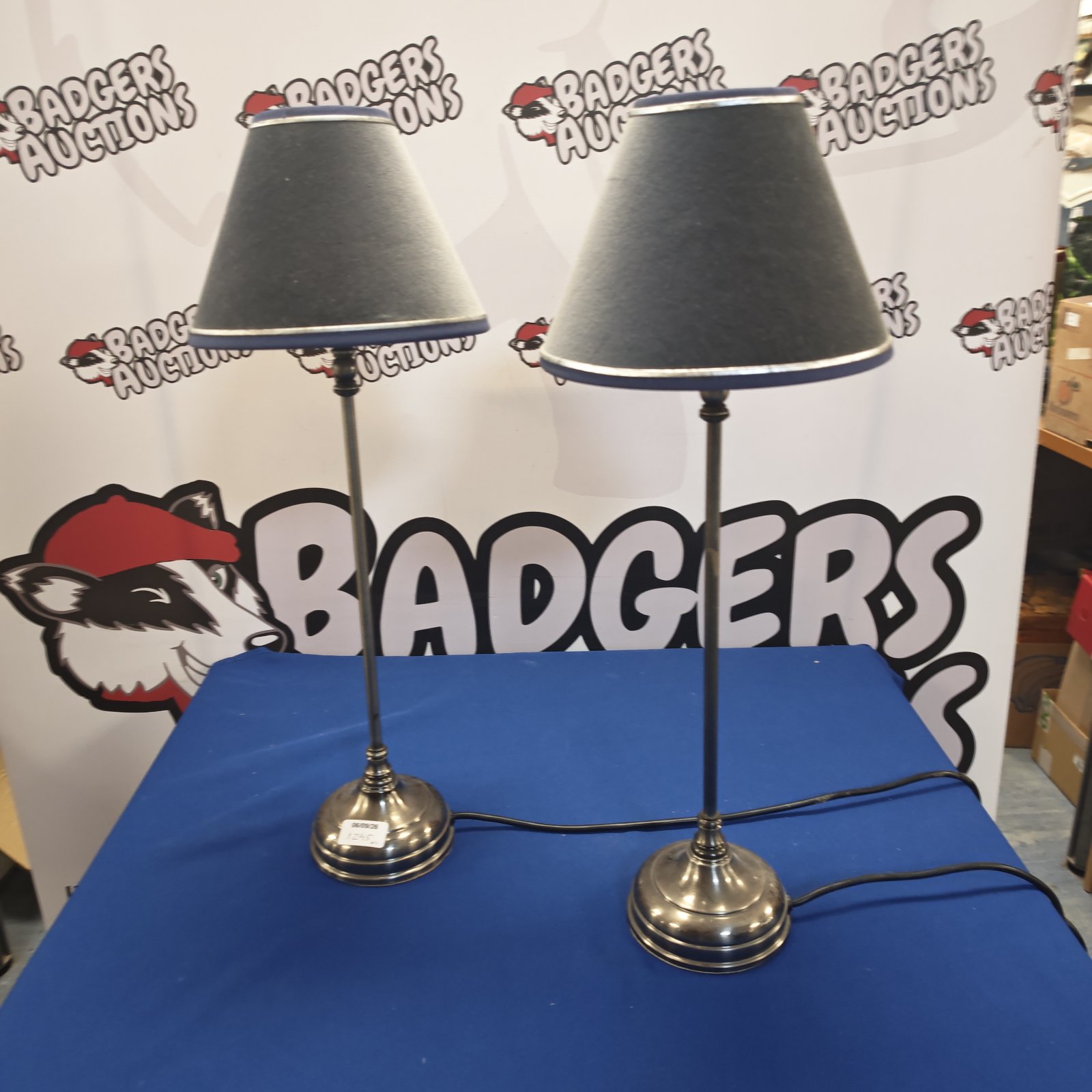 Pair of brushed steel table lamps with grey shades.