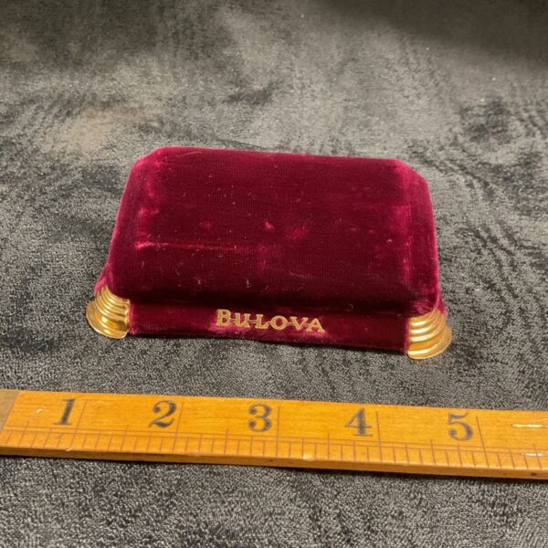 Vintage Bulova watch box in burgundy velvet with gold trim.