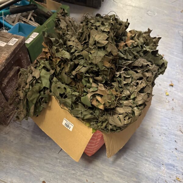Box of used camouflage netting for outdoor concealment.