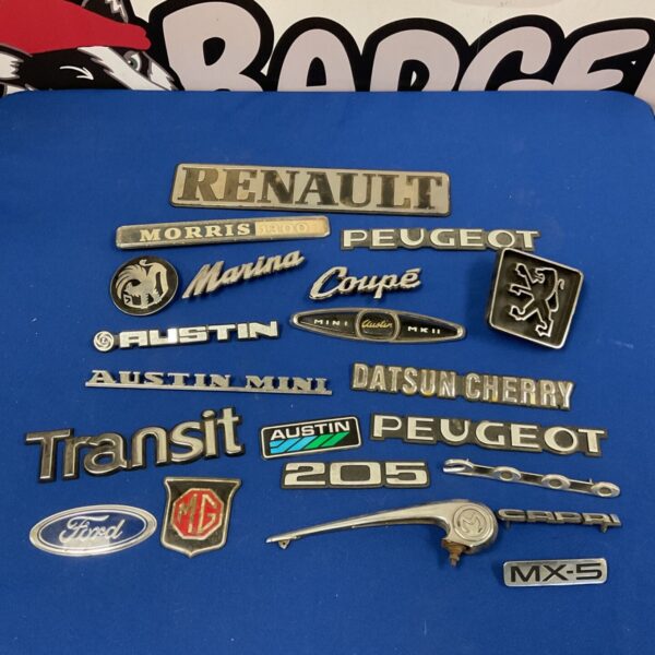 Vintage car badges collection including Austin Mini and Ford Capri emblems.
