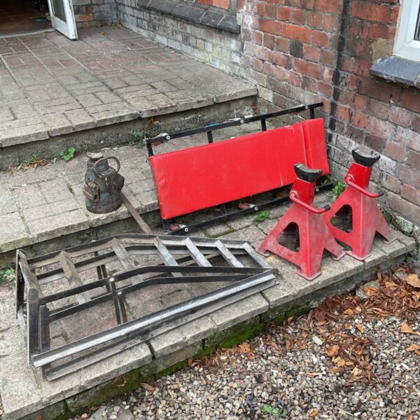 Automotive car ramps and axle stands set for vehicle maintenance.