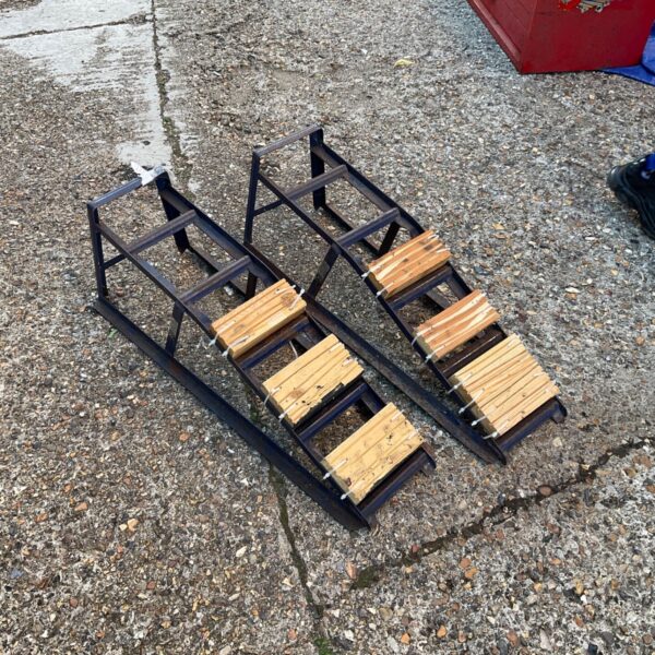Pair of used steel car ramps for automotive maintenance.