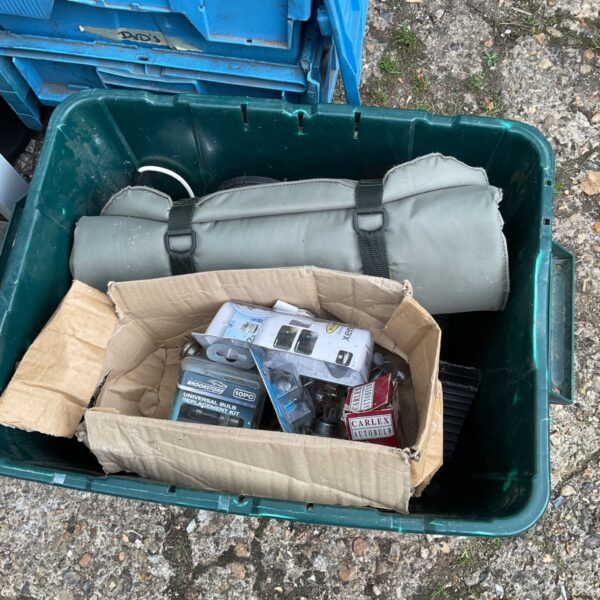Blue box filled with assorted car spares and automotive parts.