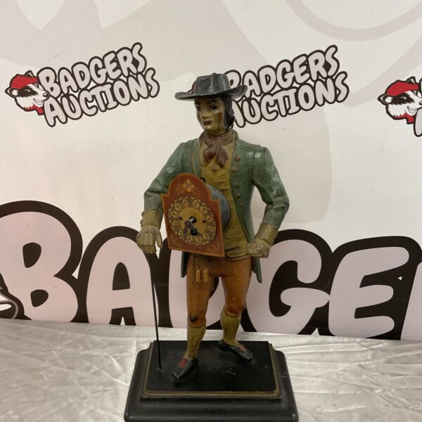Vintage cast iron clock peddler figure with detailed clock display.