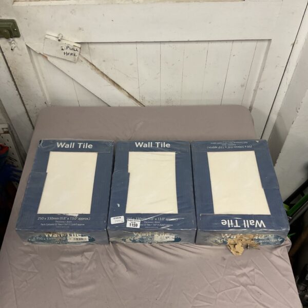 Three boxes of ceramic wall tiles stacked, showing storage wear.