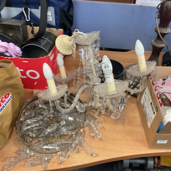 Disassembled glass arms from a vintage chandelier, awaiting repair.