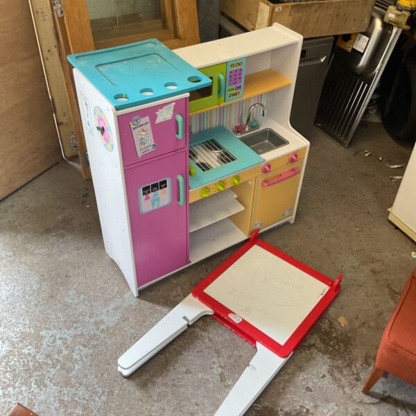 Colourful childrens play kitchen with attached whiteboard for creative play.