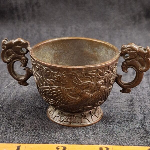 Vintage Chinese bronze temple cup with dragon handles and phoenix carvings.
