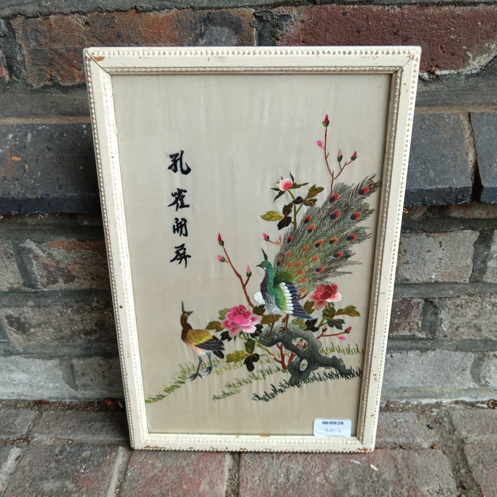 Vintage Chinese silk embroidery featuring detailed peacock design.