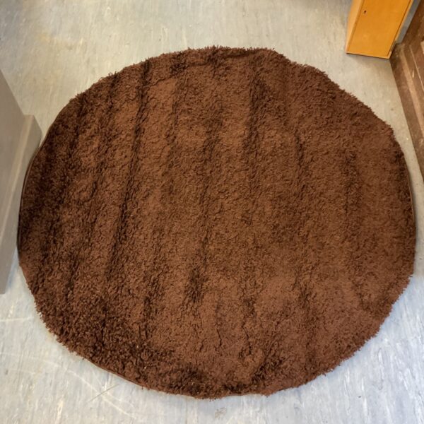 Chocolate brown shaggy rug on a light floor.