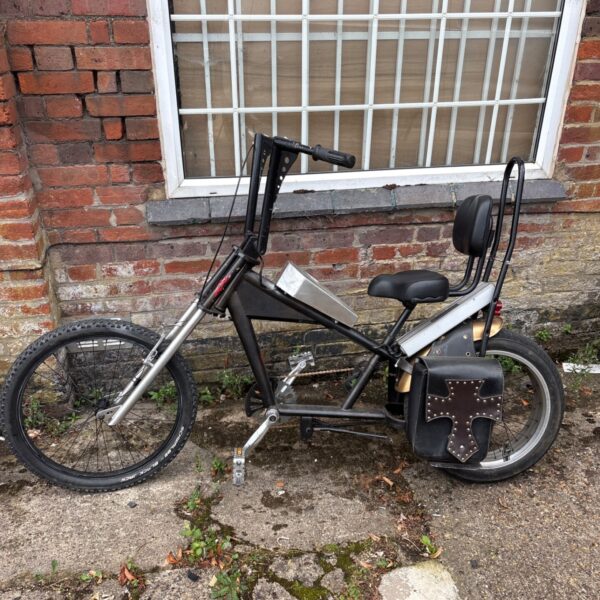 Custom chopper bike with electric assist motor, unique bicycle design.