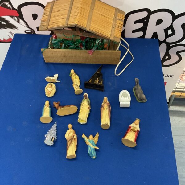 Vintage Christmas manger scene with Nativity figures and lighted stable.