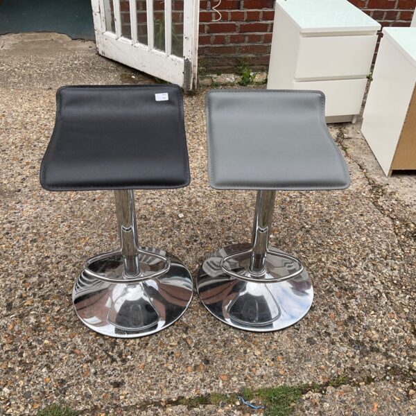 Pair of modern chrome kitchen stools with black seats.