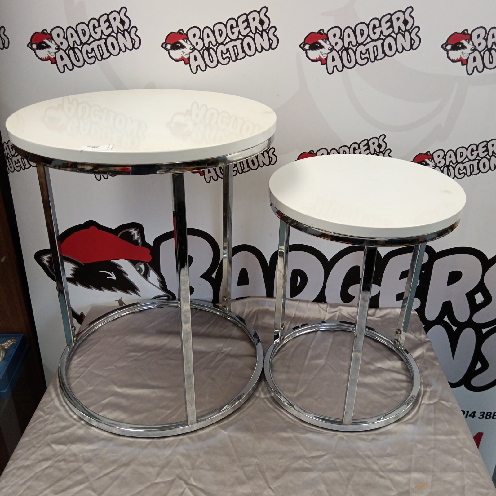 Modern chrome nest of tables with white tops.