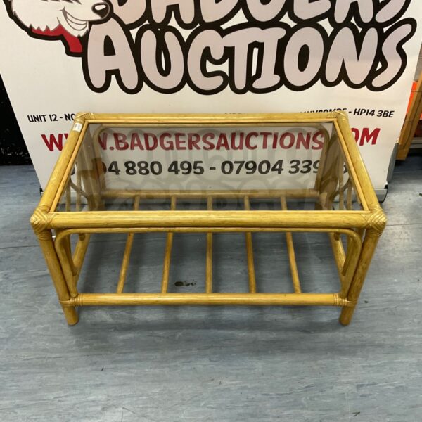 Vintage coffee table with glass top and wooden frame.