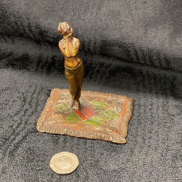 Vintage cold painted bronze figure on patterned carpet.
