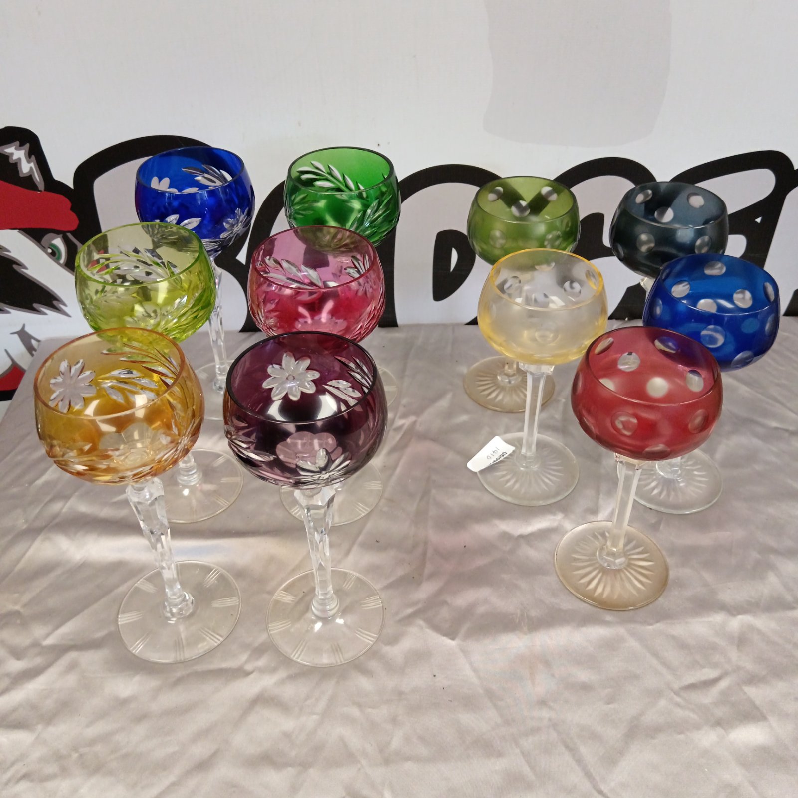 Collection of six colourful cut glass wine glasses.
