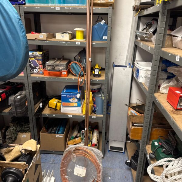 Shelf with copper pipe bundle and various tools.
