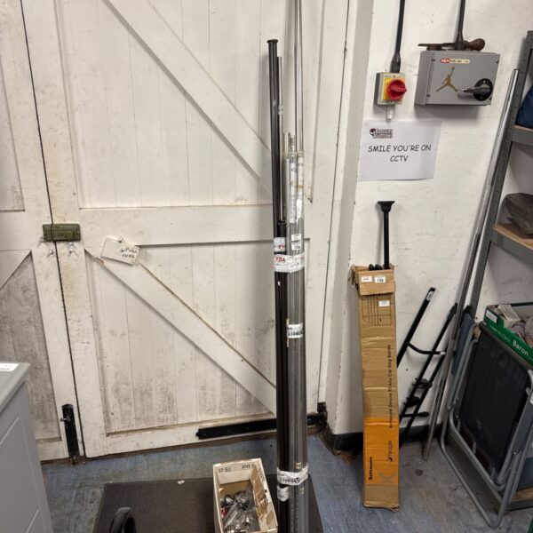 Metal curtain rail poles and fittings in a storage area.