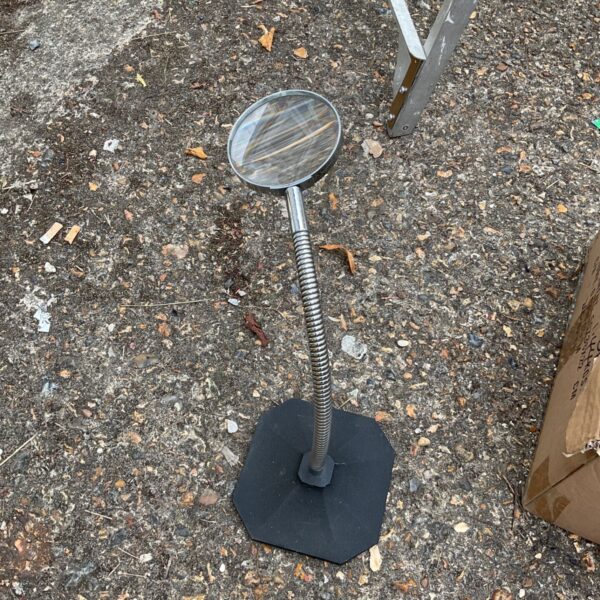 Black base desktop magnifying glass with flexible gooseneck.