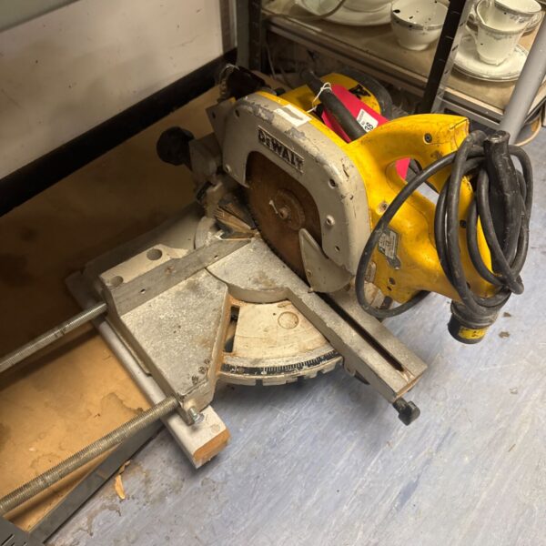 Vintage Dewalt chop saw for metal cutting in a workshop setting.