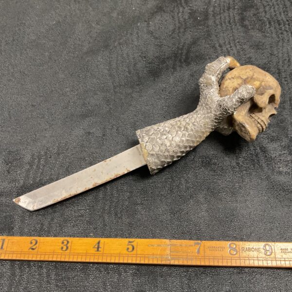 Vintage dragon claw dagger with skull detail.
