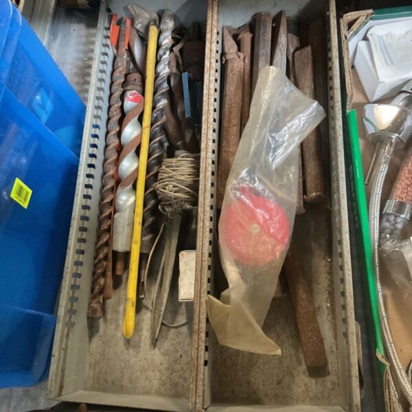 Assortment of drill bits and cold chisels in a blue storage box.