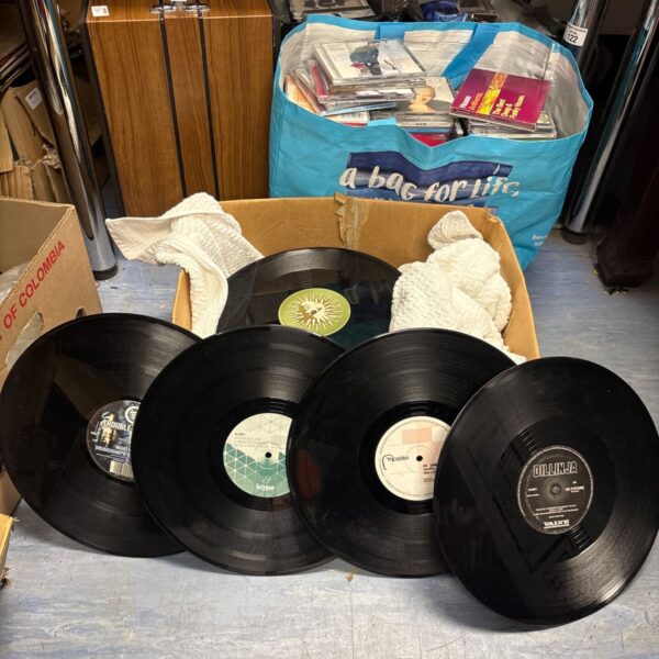 Stack of drum and bass vinyl records with a bag for life in the background.