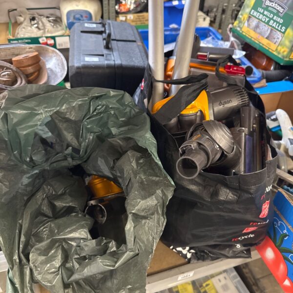 Two bags of Dyson cordless hoover parts and components.