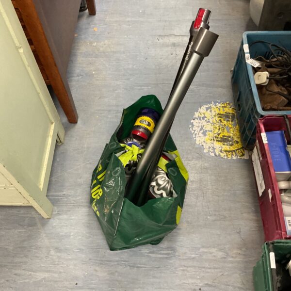 Used Dyson vacuum cleaner with attachments for home cleaning.