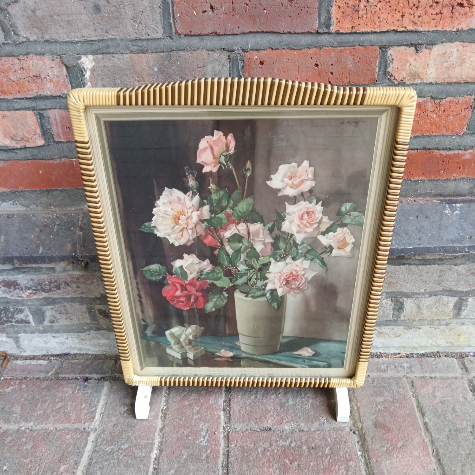 Vintage Edwin Byatt fireguard screen with a rose print and wicker frame.