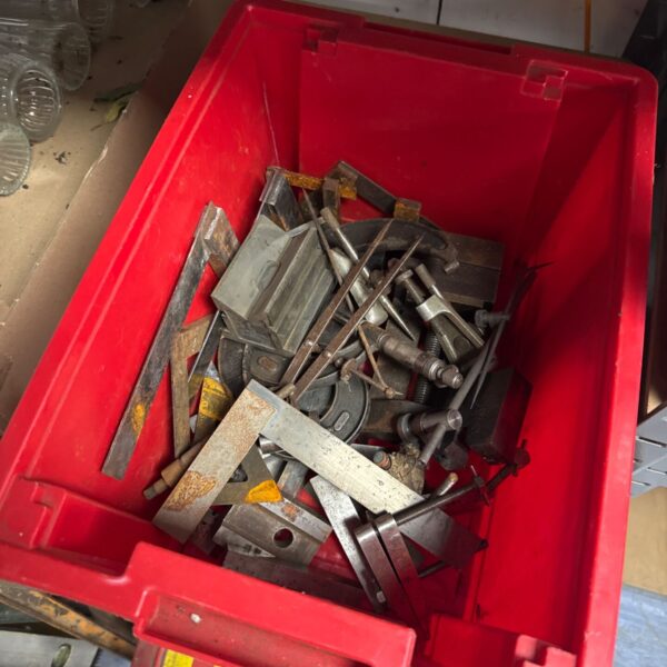 Assorted engineering tools in a red storage box.