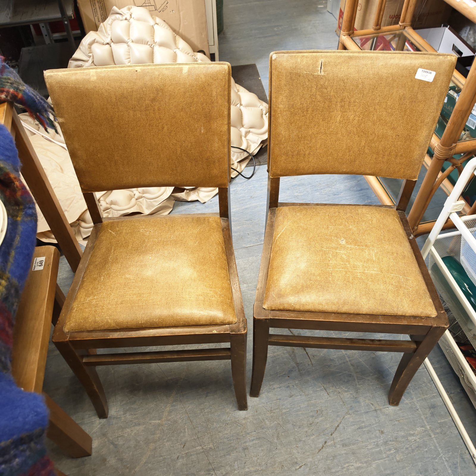 Vintage Ercol dining chairs with leather seats in a warm interior setting.