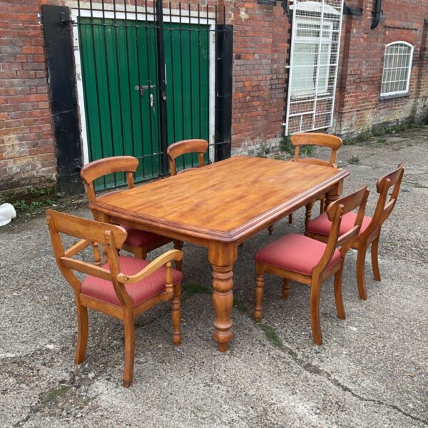 Vintage farmhouse dining table and four chairs in a kitchen setting.