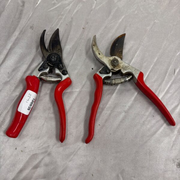 Red Felco pruning shears for garden maintenance.