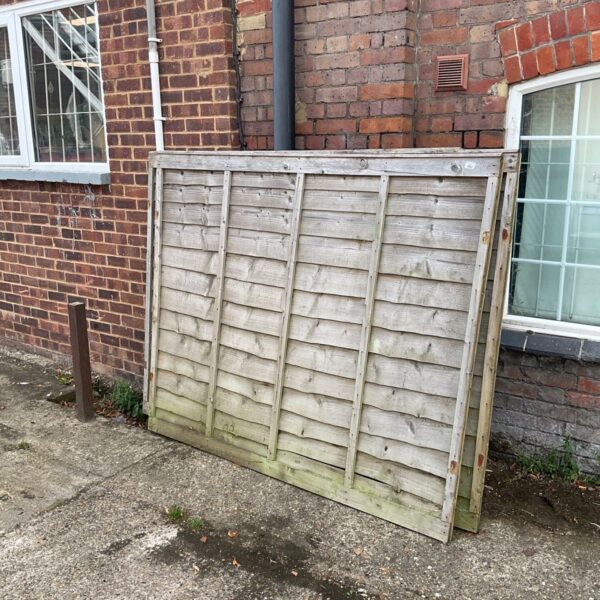 Weathered wooden fence panels in a garden setting.