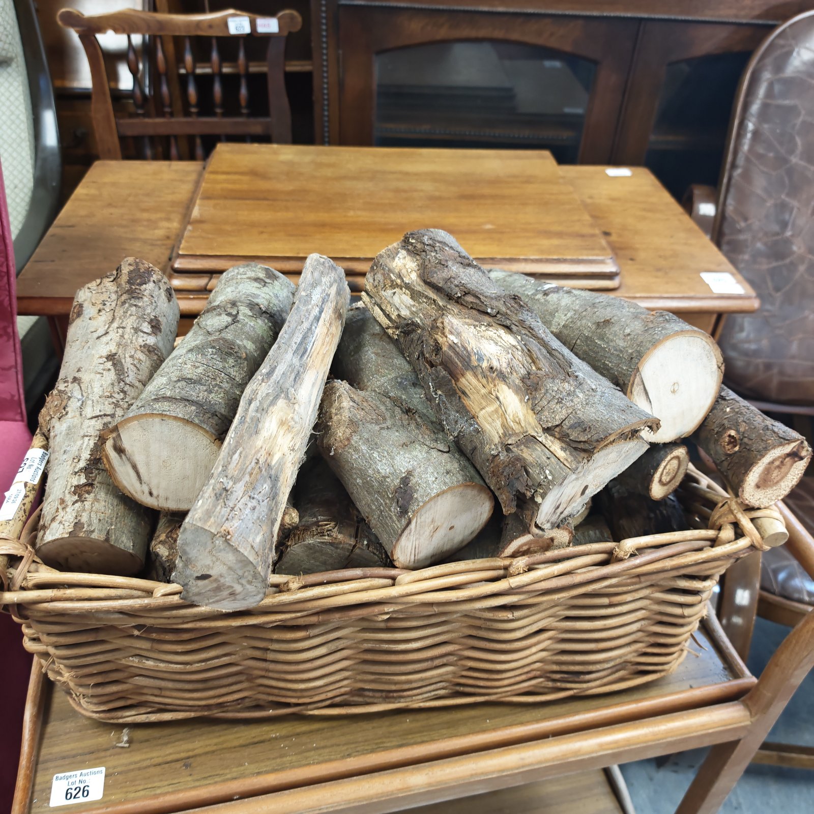 Wicker basket overflowing with seasoned firewood logs for winter.