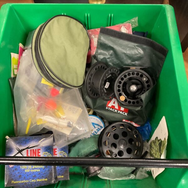 Open fishing tackle box with assorted carp fishing line and accessories.