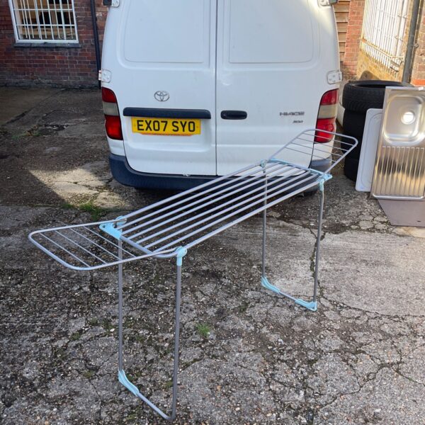 Silver folding aluminium clothes airer against a van.