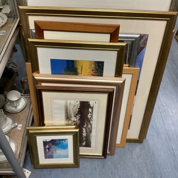 Assortment of vintage framed artwork in gold frames.