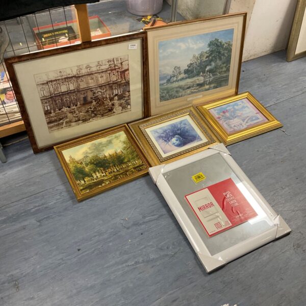 Assorted framed artwork including landscapes and floral prints.