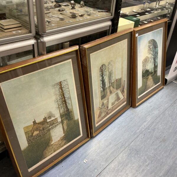 Set of three framed rural prints depicting countryside scenes.