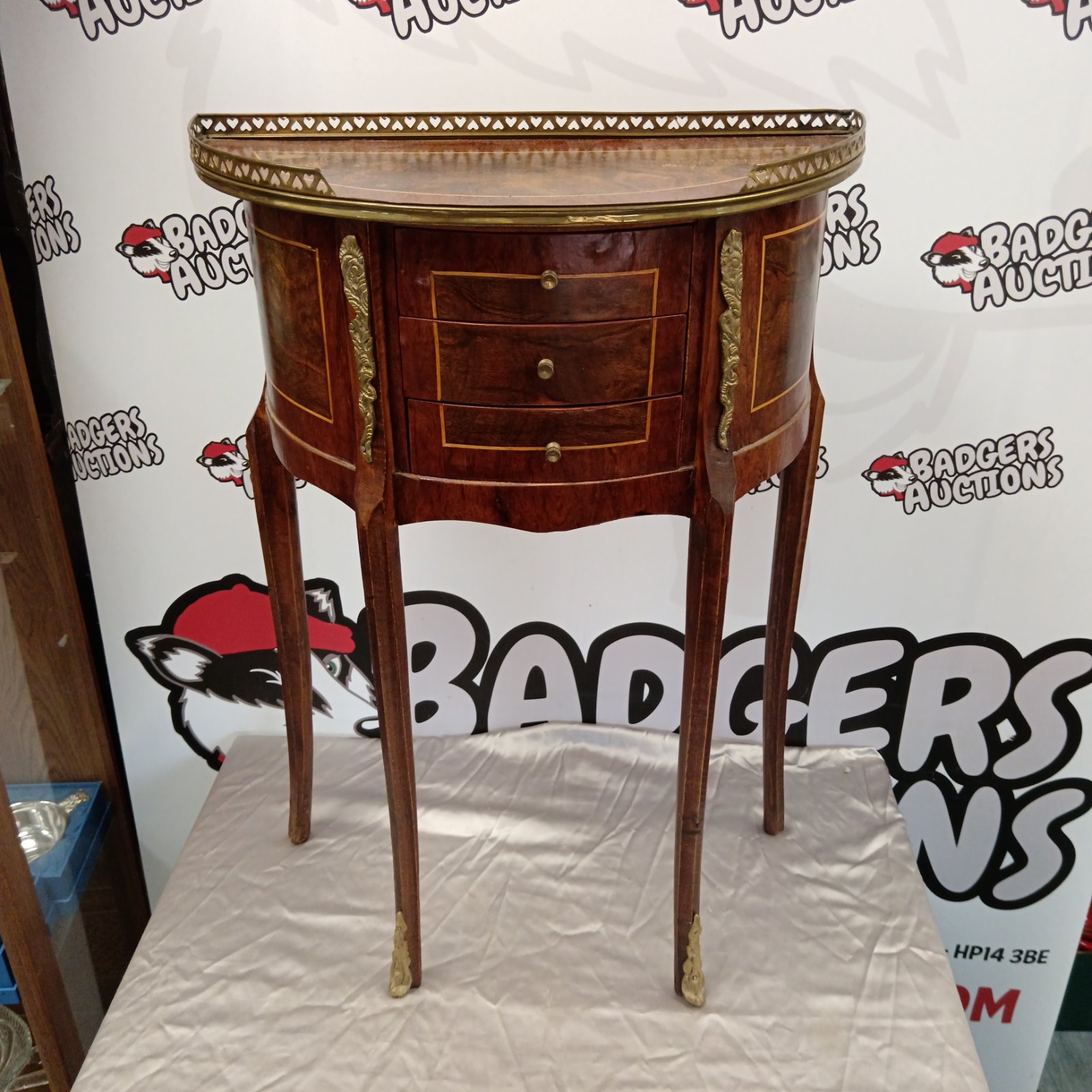Vintage French demilune table with marquetry and brass details.
