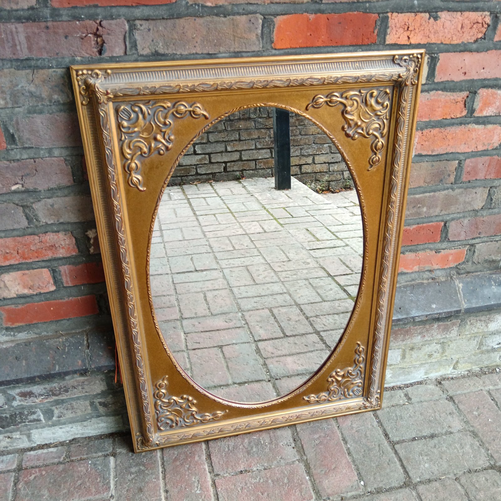 Ornate French style gilt mirror with a detailed frame.