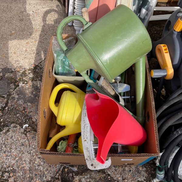 Garden accessories lot including watering cans and hosepipe.